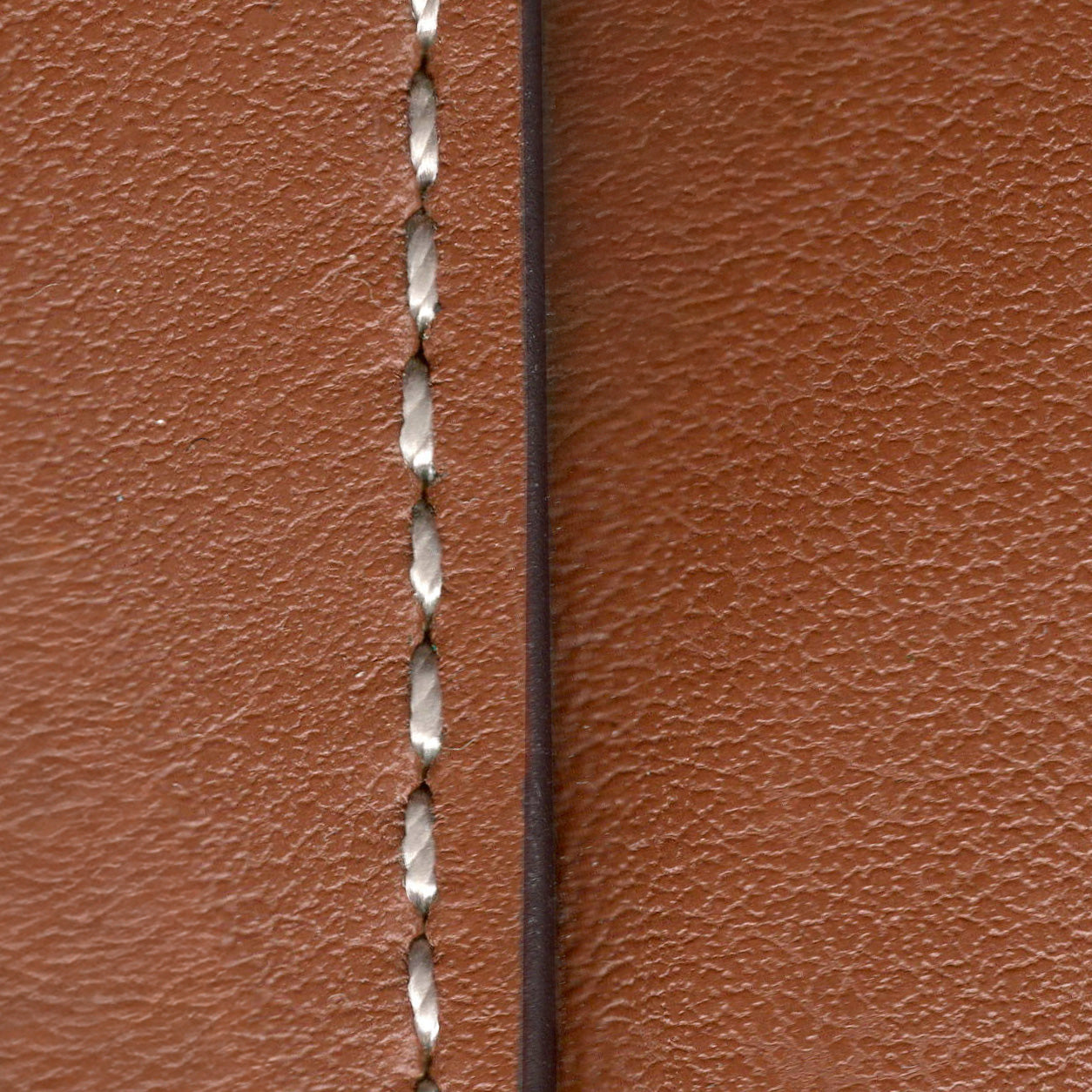 Close-up of brown leather with a visible stitching detail